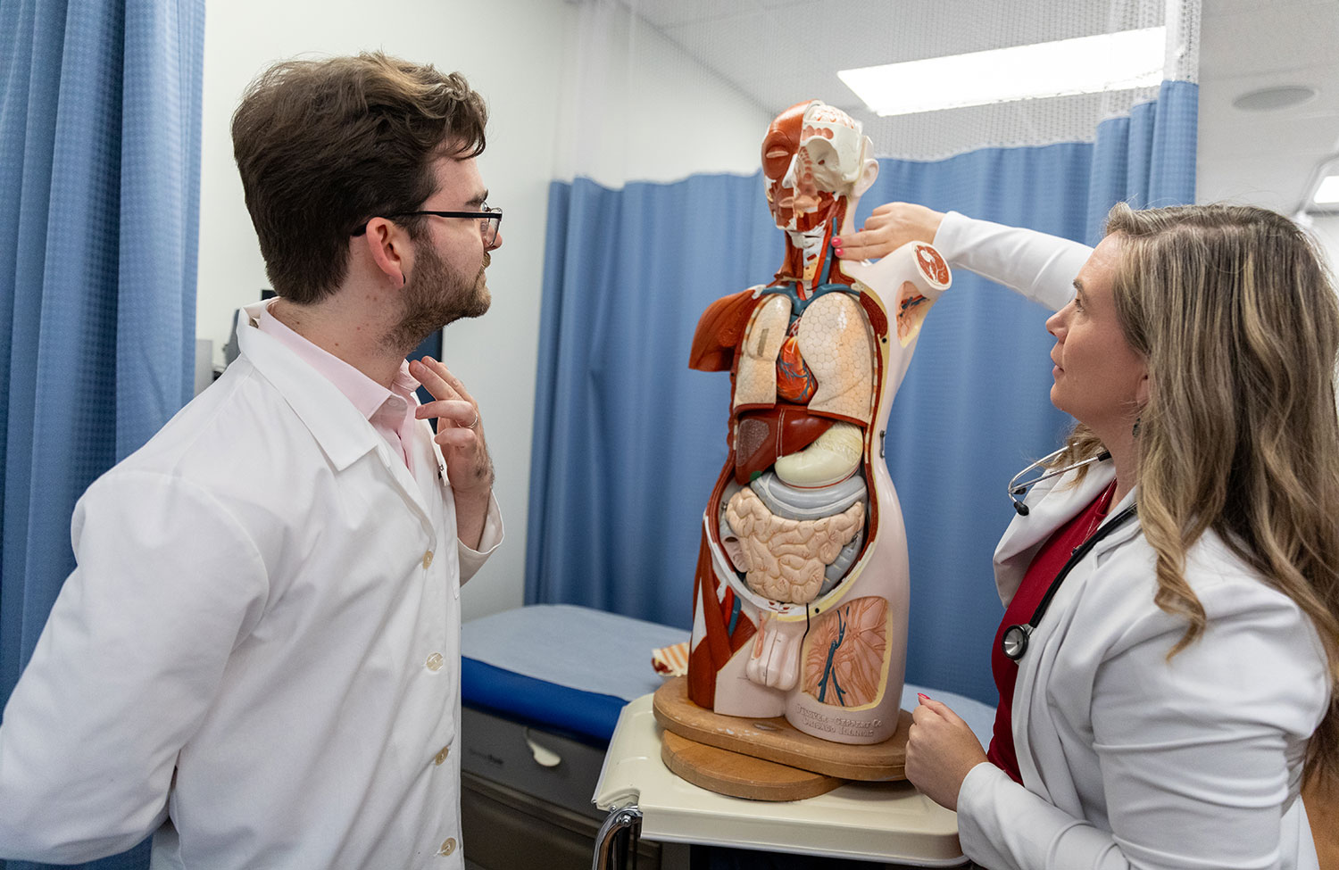 Student and Teacher look at a diagram of the human body.