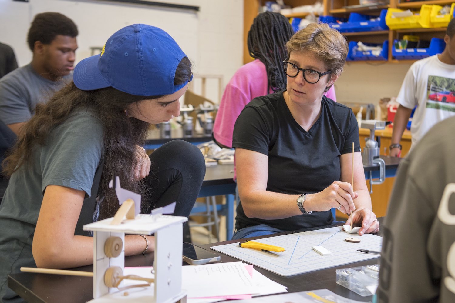 An Edge student in an Engineering class speaks with the instructor as they work on a project.