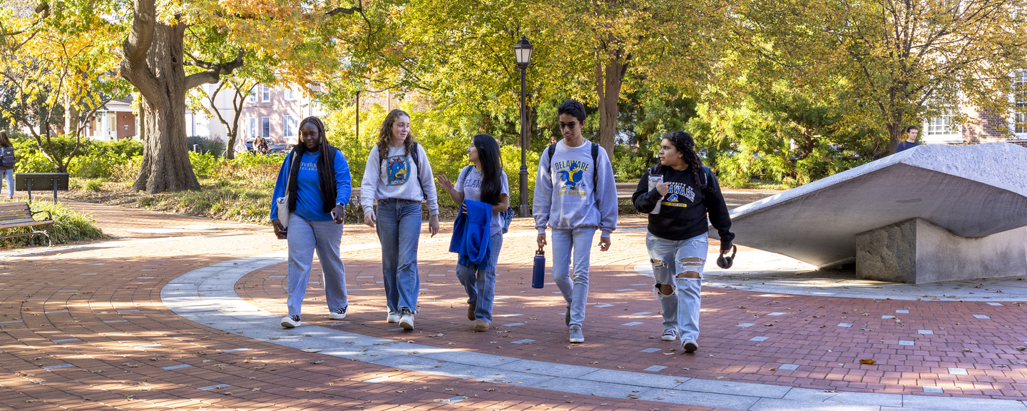 Group of students walking across campus together