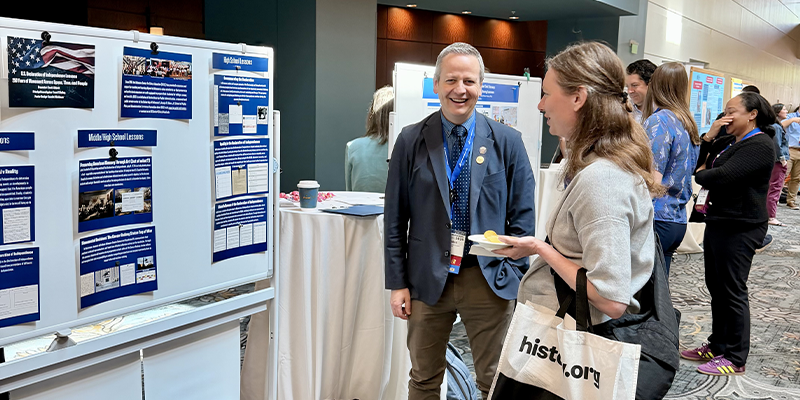 Scott Abbott and NCHE Conference attendee stand in front of his poster presentation