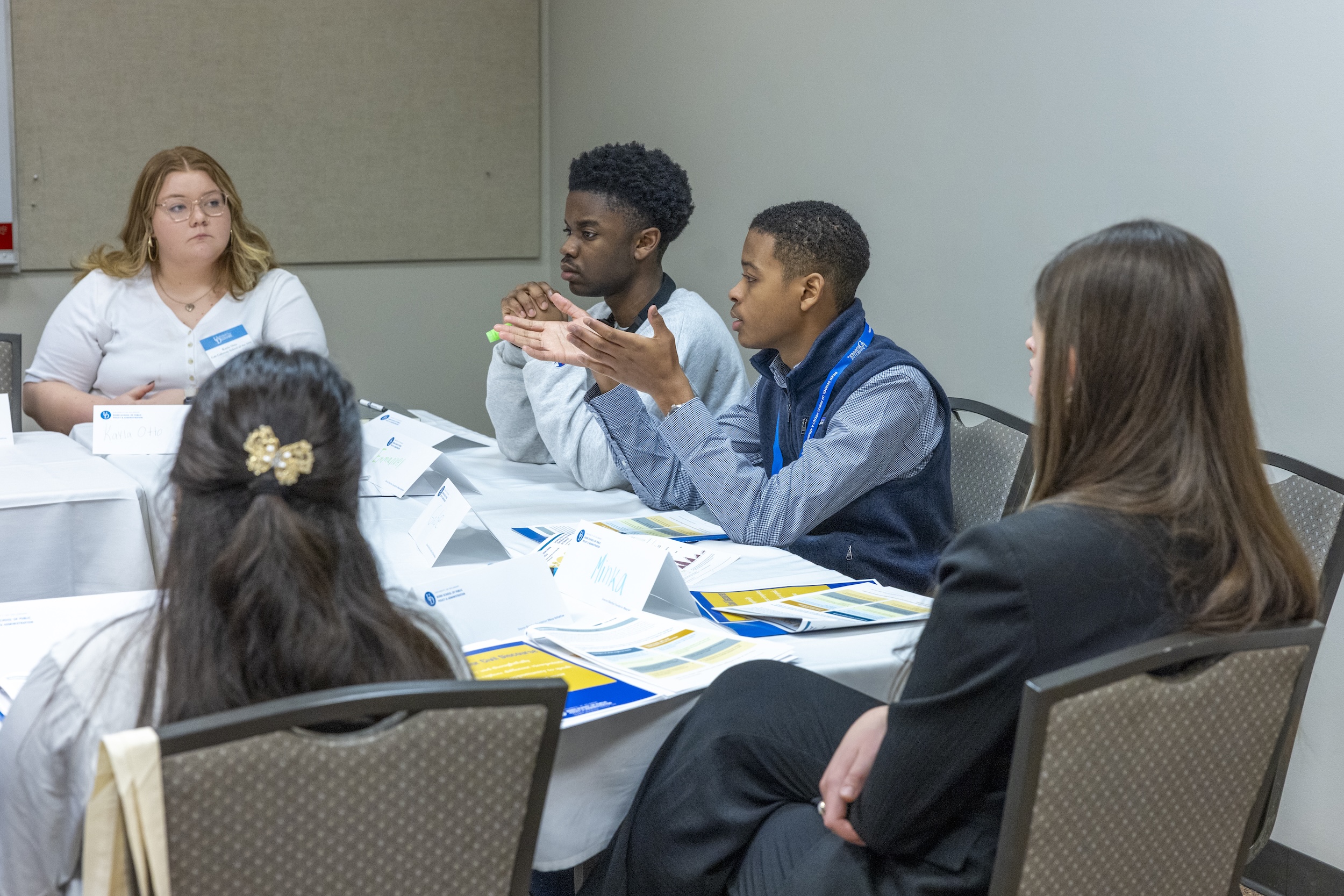 Students chatting around a table at DE Dialogues