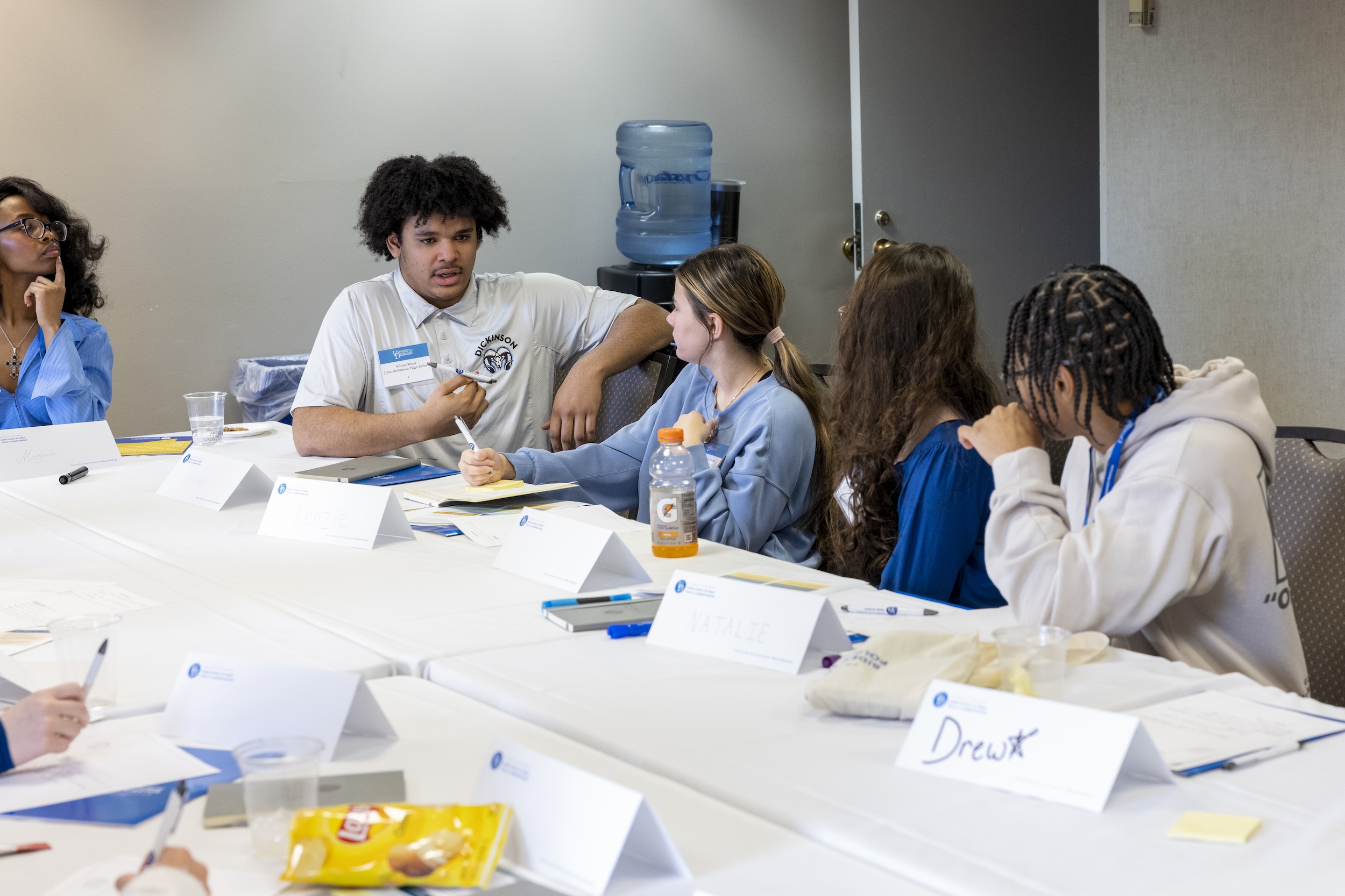 Students chatting around a table at DE Dialogues