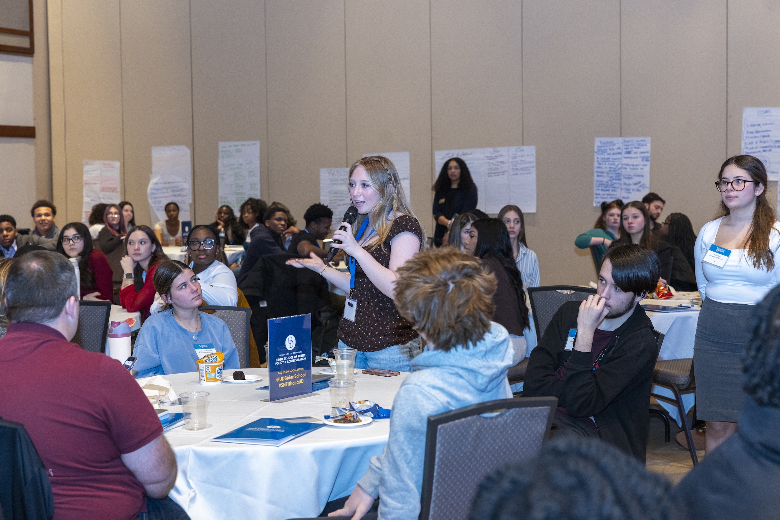 Student speaking into a microphone at DE Dialogues