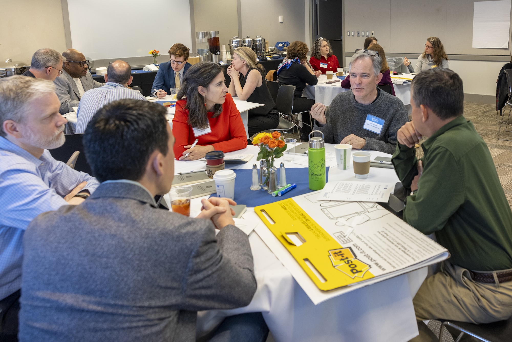 Attendees speaking around a table at the SNF Ithaca National Leadership Summit