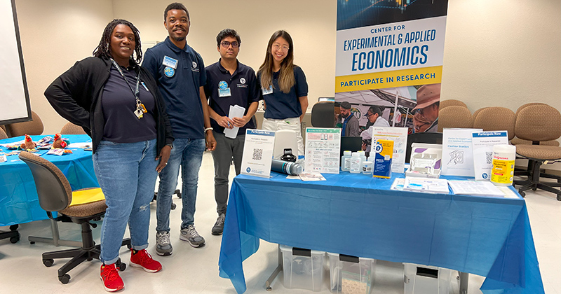 Group photo of student set up to accept surveys with Center for Experimental and Applied Economics