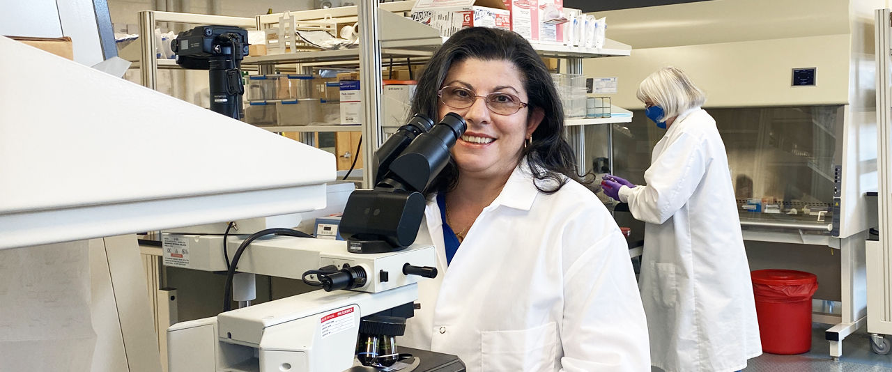 Dr. Nanette Olmeda-Geniec at microscope