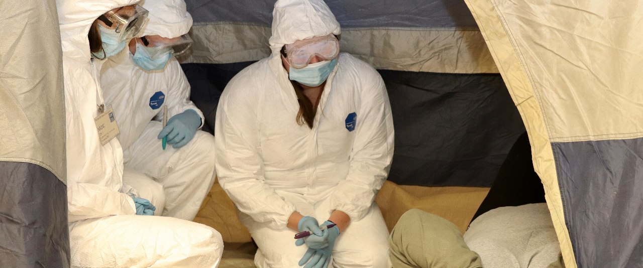 Three students take an experiential medical entomology final exam in full protective gear.