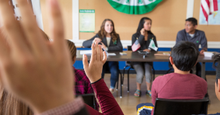 Children raising their hands in a classroom environment