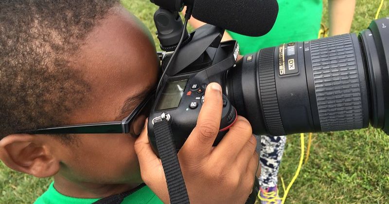 A little boy tests out a camera.