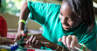 A STEAM participant using scissors for a craft.