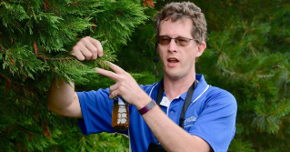 Brian Kunkel, Extension Agent explaining what is happening to an evergreen