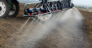 The back of a farm tractor spraying the fields