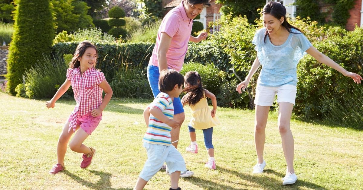 Parents playing with their children in the backyard