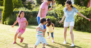Parents playing with their children in the backyard