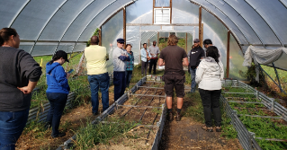 Participants in the Beginning Farmer Program standing in a green house