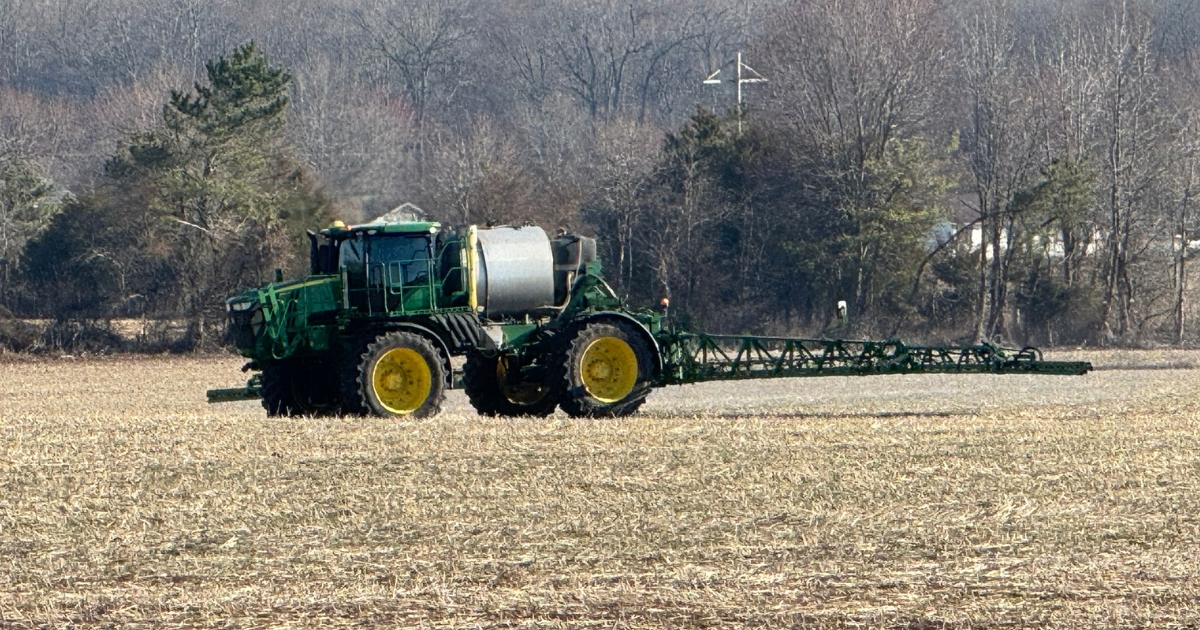 A tractor in a field applying lime