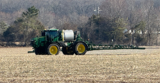 A tractor in a field applying lime