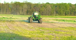 A tractor in a field applying lime