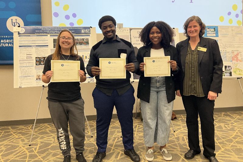 The winners of the Ph.D. category for research pose with Tanya Gressley for a photo, holding their certificates.