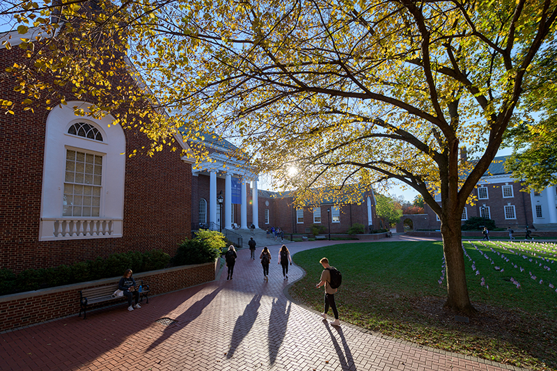 Students walking on The Green in front of Memorial Hall on a sunny fall day.