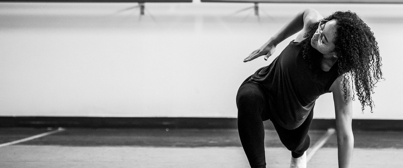 One woman of color dancing in a contemporary setting, it is a black and white photo