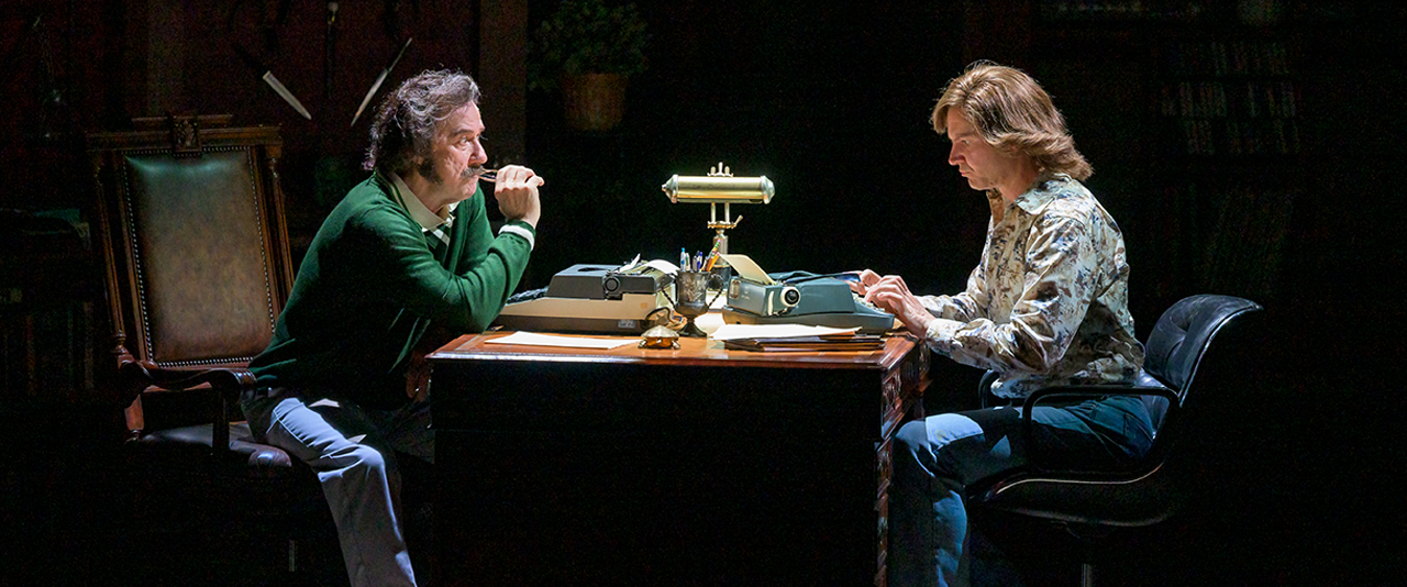 Two white men sitting at a desk with type writers