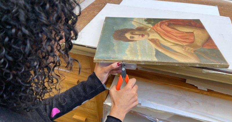 Art Conservation Fellow Taryn Nurse dismounting a painting 
