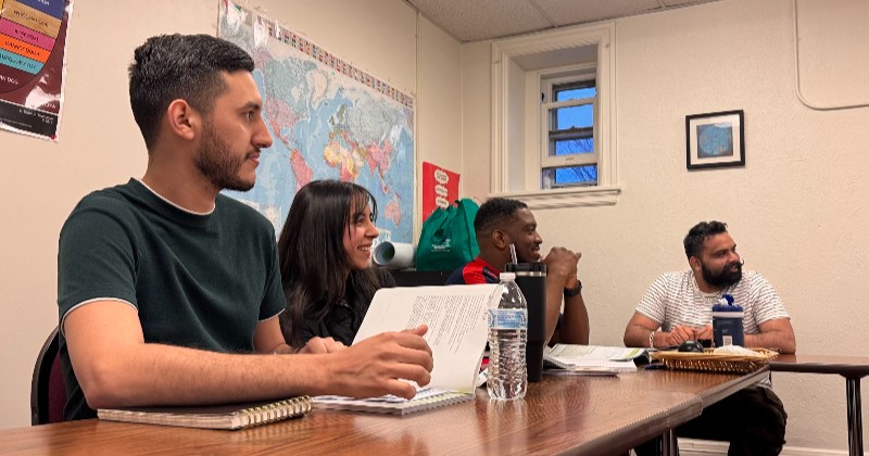 Estudiantes sentados en escritorios en un aula