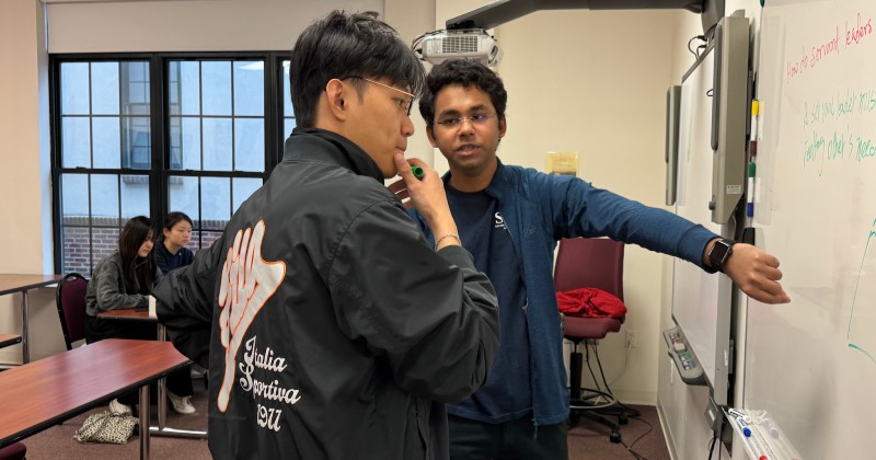 Two students looking at a whote board