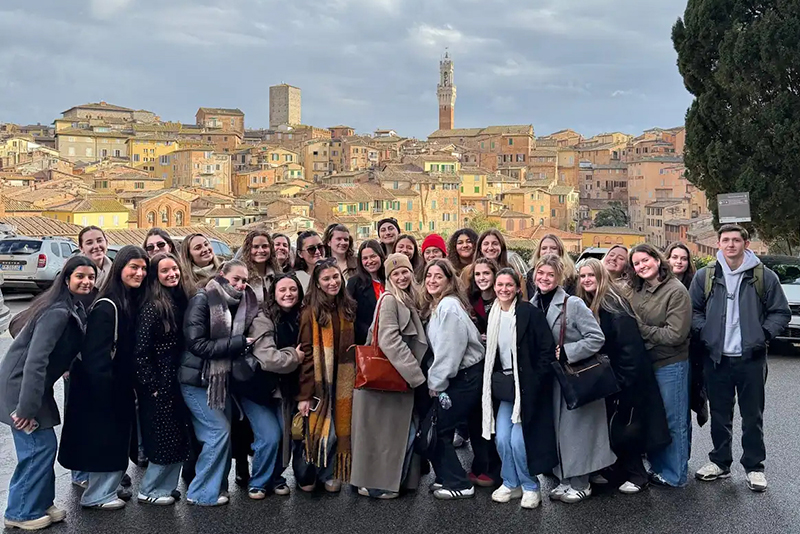 A group photo of University of Delaware students in front of the Florence, Italy, skyline