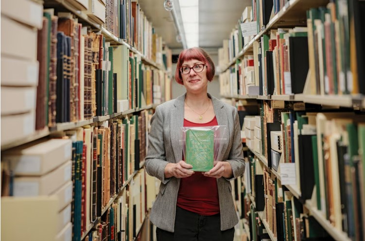 Melissa Tedone holding poison book in library