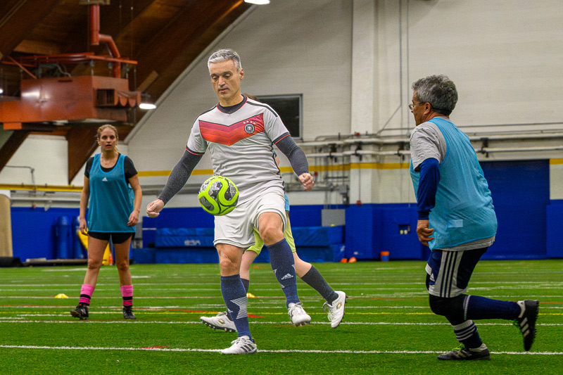 Four UD faculty members playing soccer in the Field House