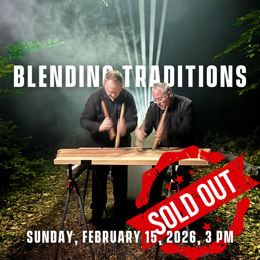 Two percussionists dressed in black and playing musical instruments