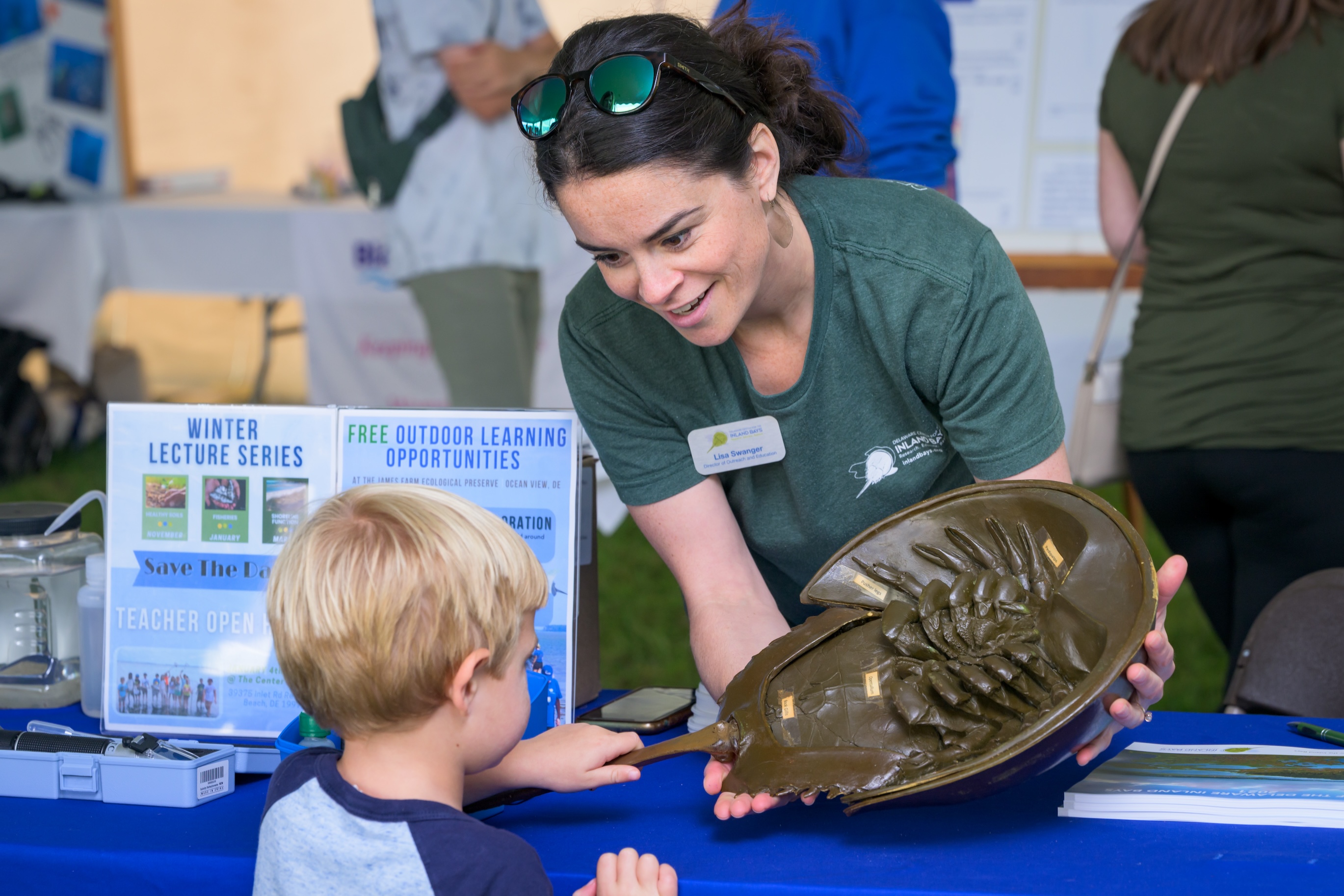 A woman demonstrates the anatomy of a horseshoe crab.