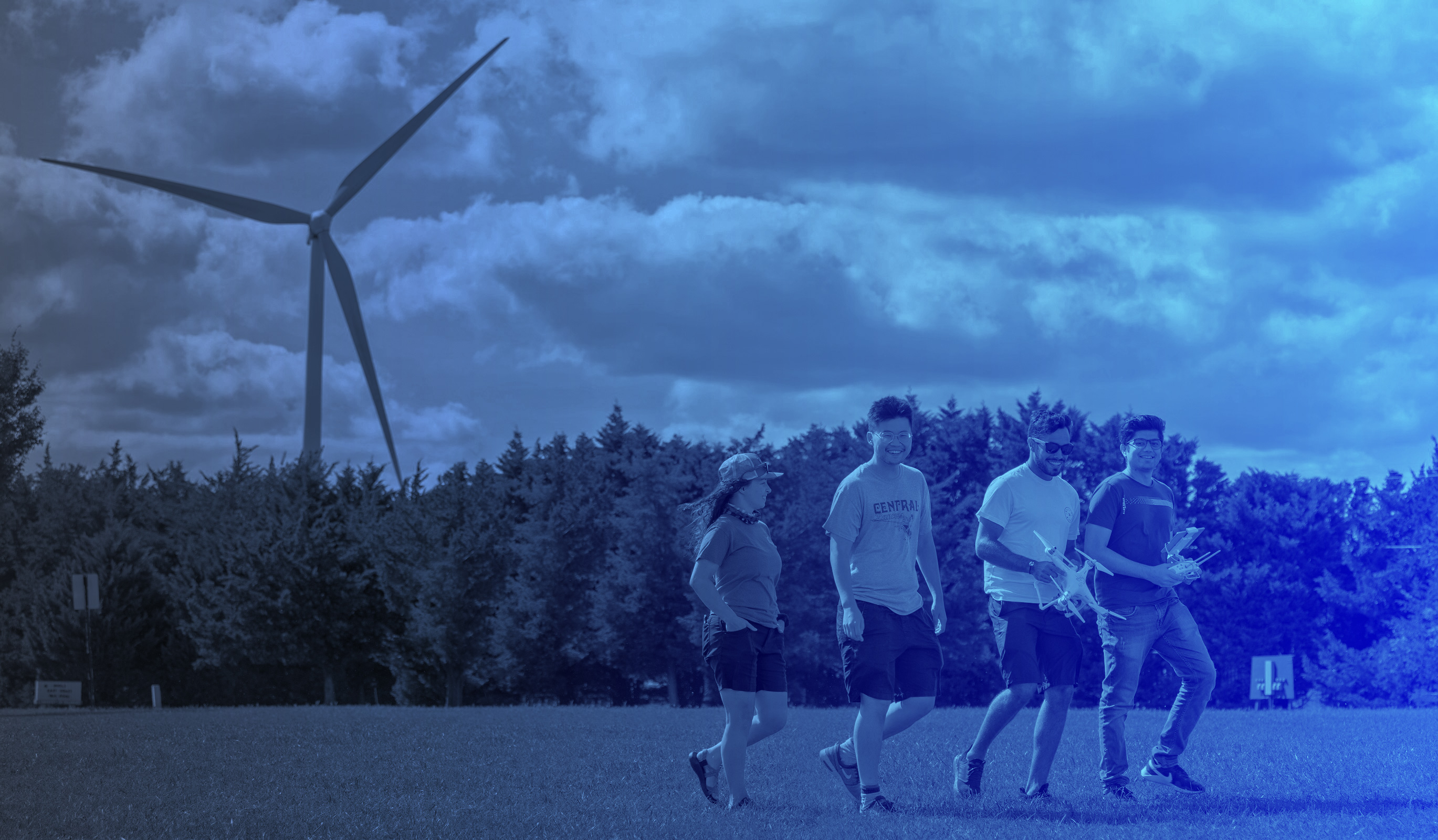Student walking in front of the wind turbine on UD's Lewes Campus
