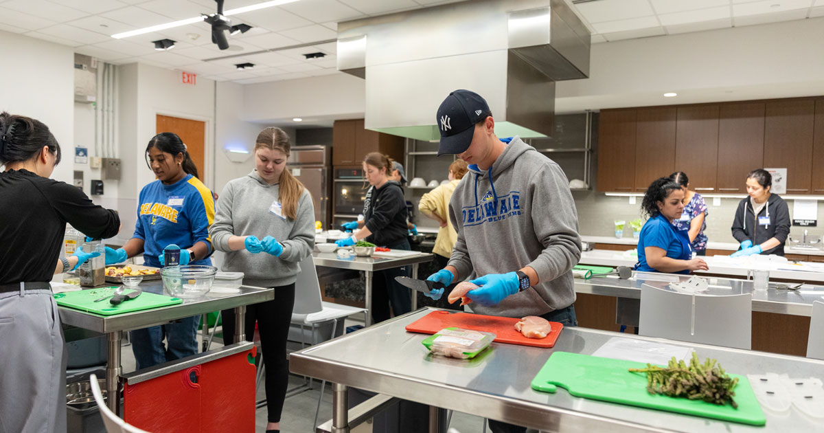 Students chop vegetables to prepare a dish in the Spice Kitchen class. 
