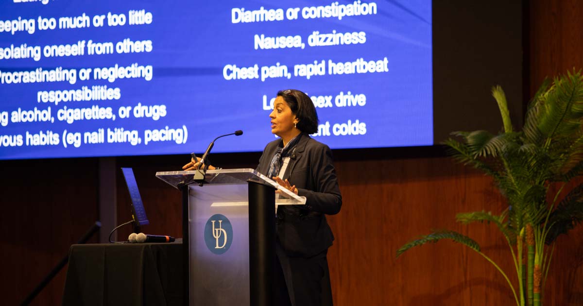 A woman standing at a podium providing her speech about stress management
