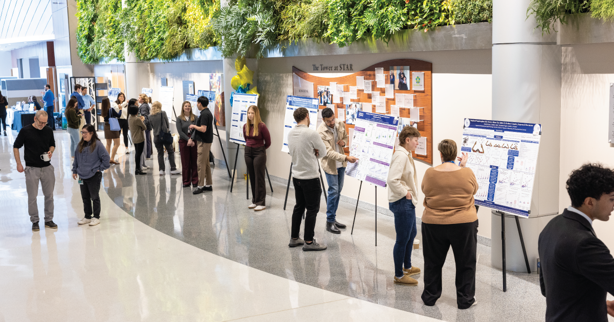 An image of students and faculty at a research poster event