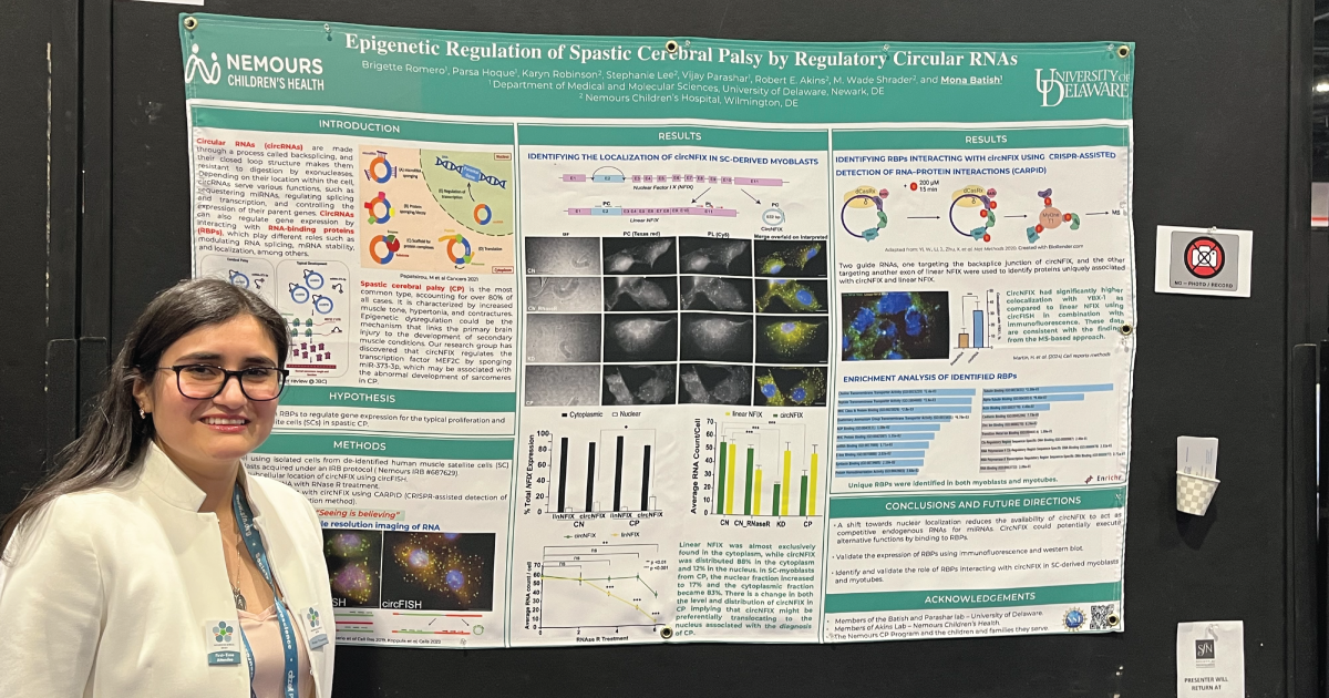 An image of a woman standing in front of her poster presenting her research about cerebral palsy