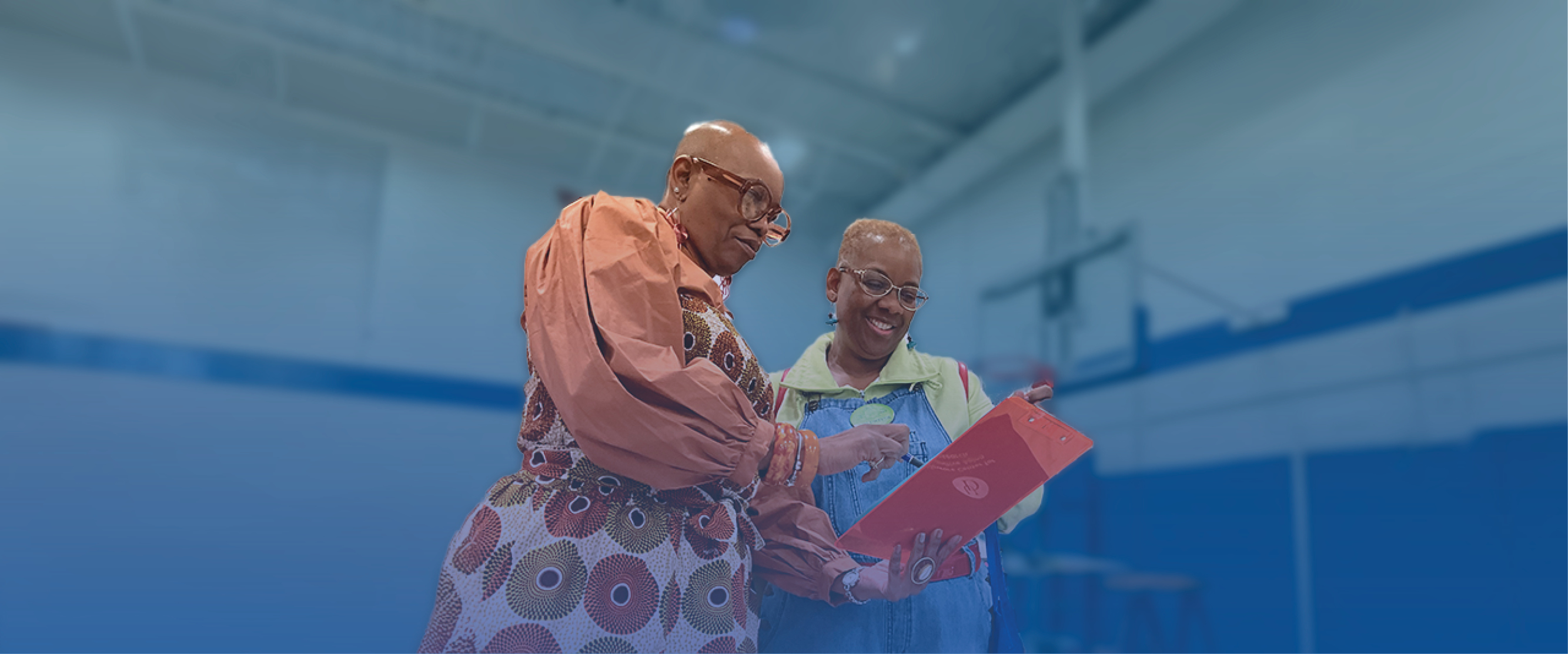Two individuals looking at a clipboard