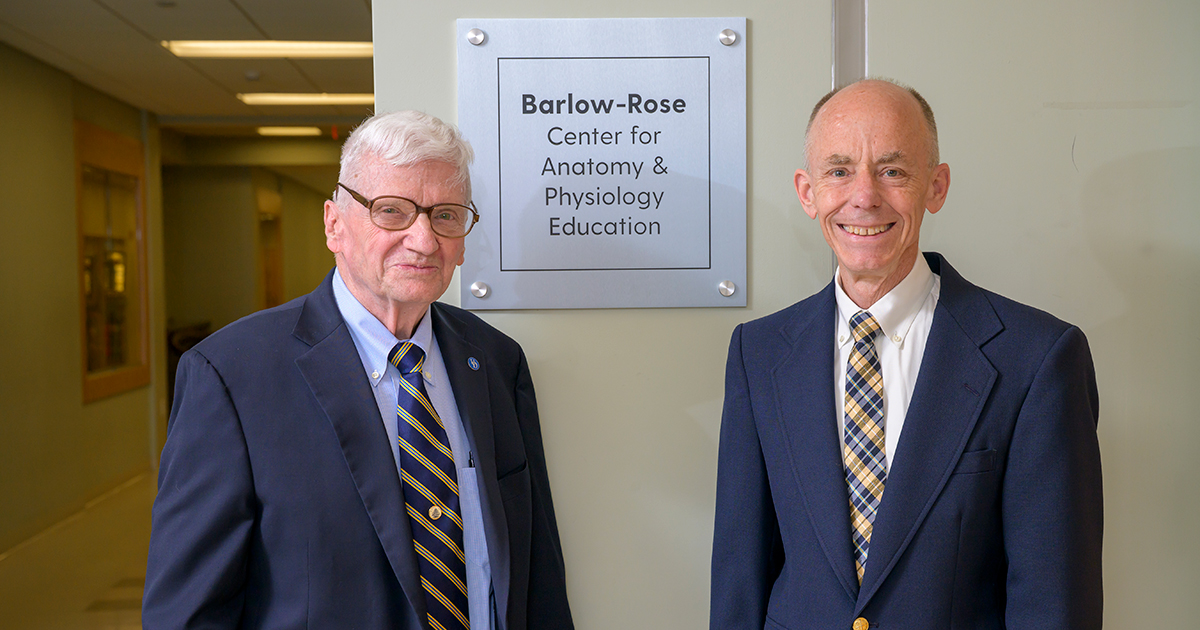 Professor Emeritus David Barlow (left) and Professor Emeritus William Rose (right) pose with a white sign between them that reads 