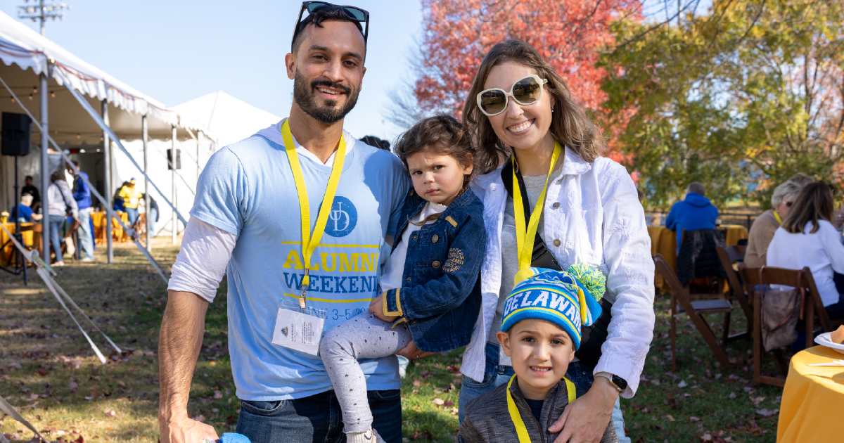 A family at the Blue Hen Tailgate at Homecoming.