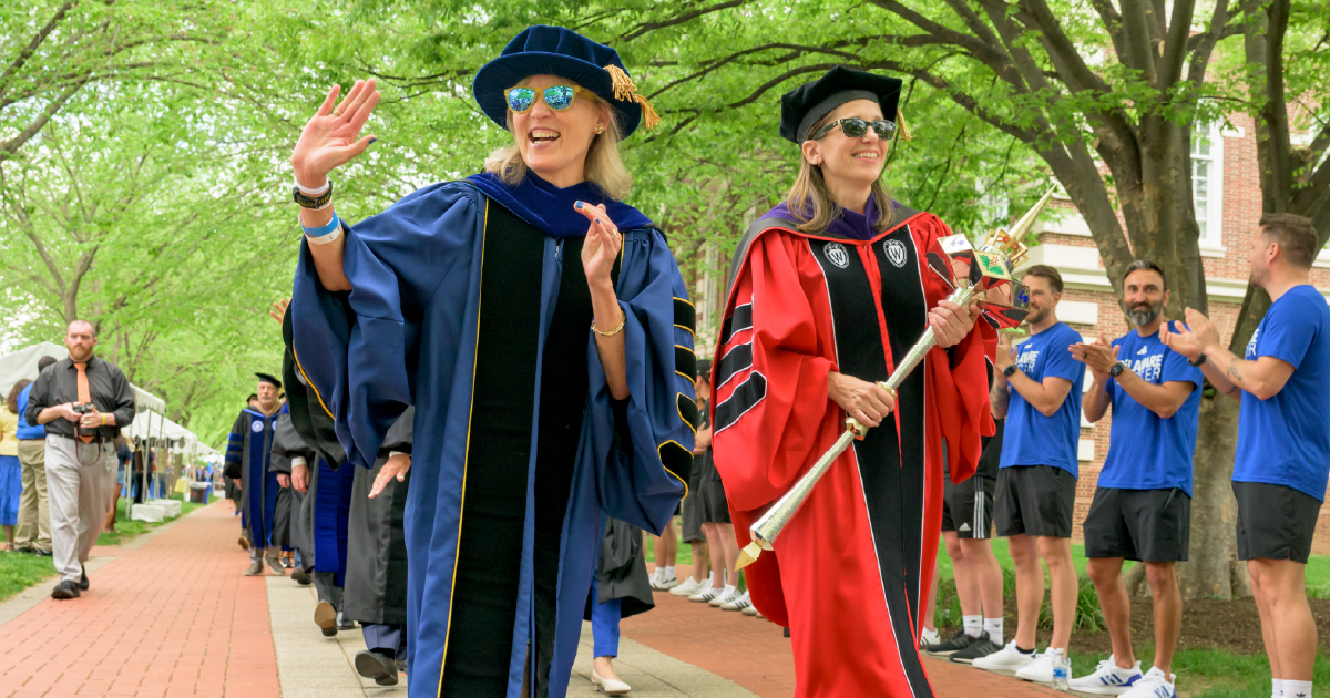 Laura Carlson in the procession, waving to the campus community.