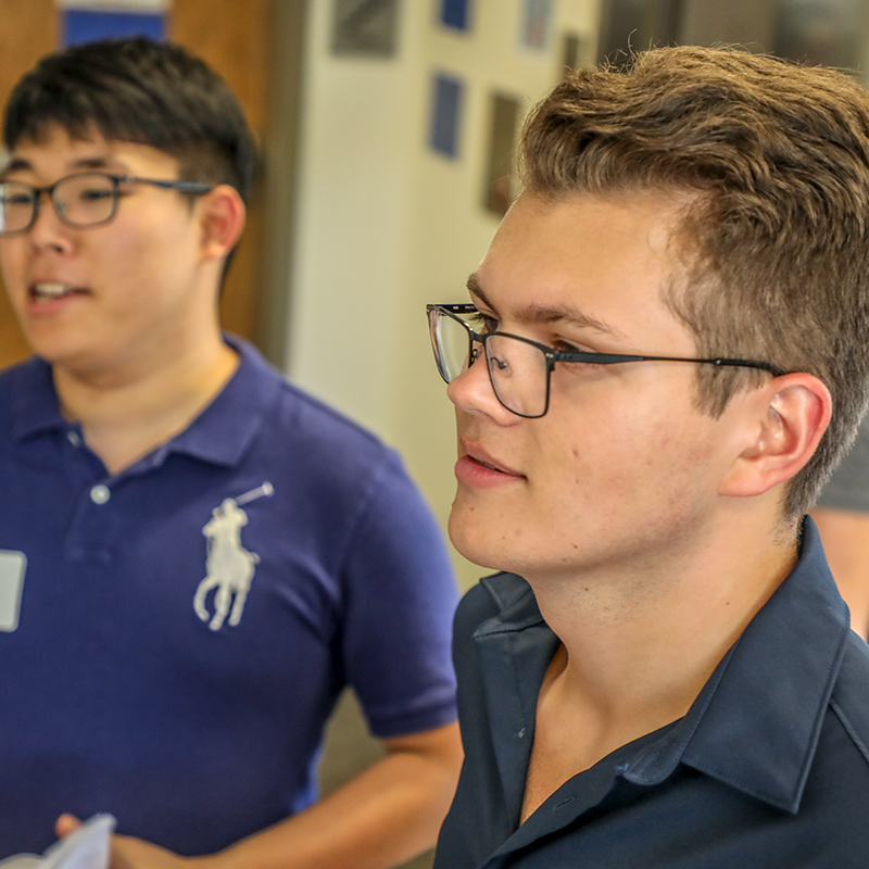 Two students look at an ideas board in the iHouse. 