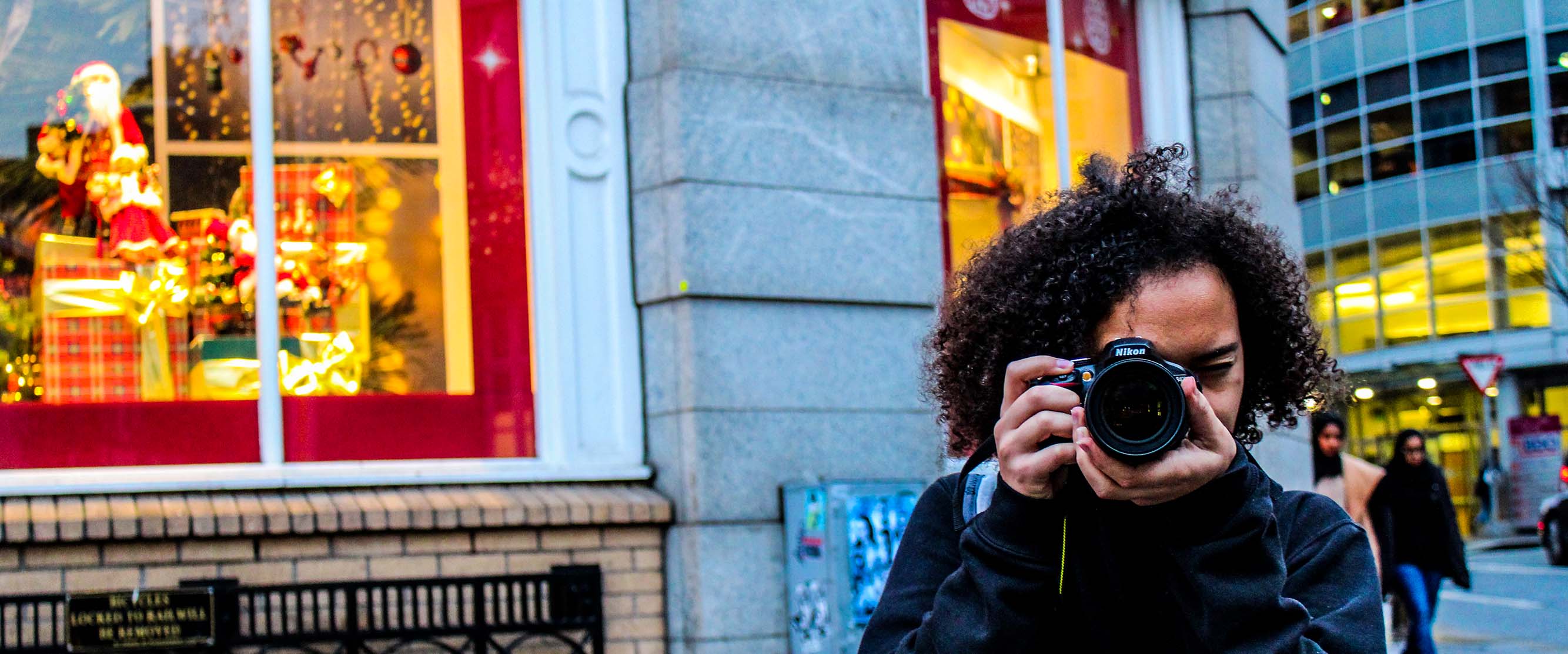 student taking a photo in front a Christmas window display in Ireland