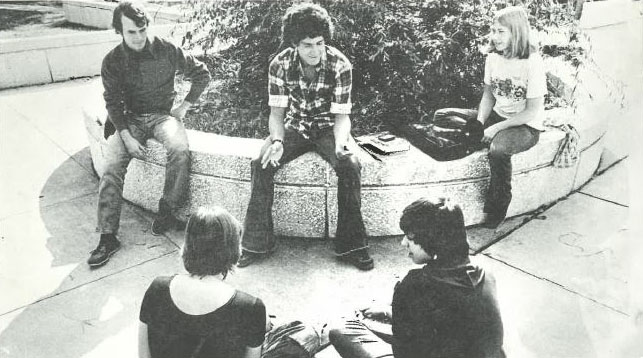 A historic image of students sitting outside on campus