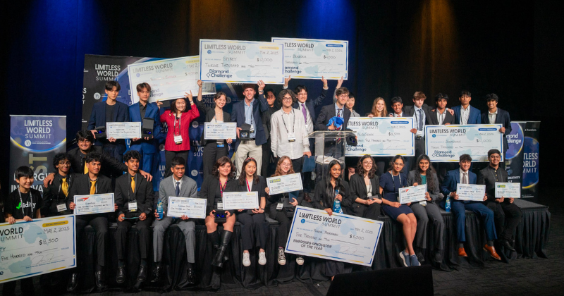 Students posing with oversized checks on stage