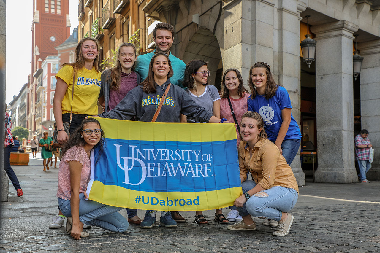 world scholars in madrid holding banner