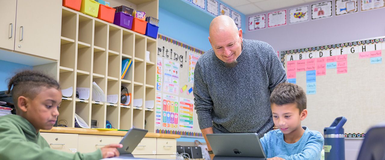 Teacher using technology in the classroom .