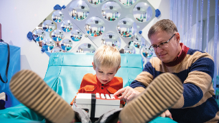 A child working with an adult on music-related research and therapy.